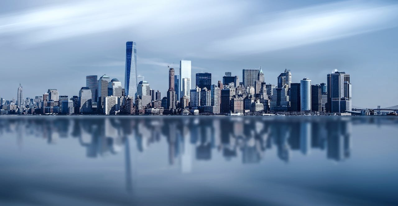 Stunning New York City skyline with modern skyscrapers reflecting on a calm river.